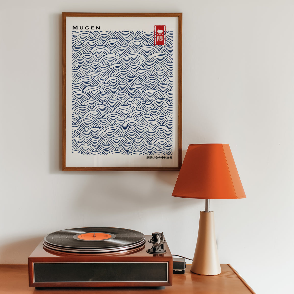 Navy seigaiha wave pattern print in a walnut frame above a sideboard with a record player