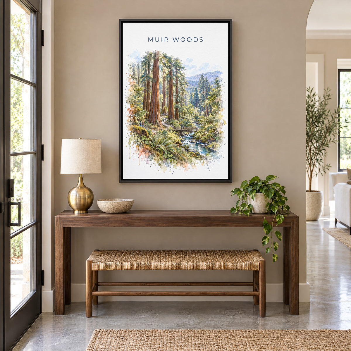 Muir Woods watercolor print as a black floater canvas above a walnut console and woven bench in an entryway