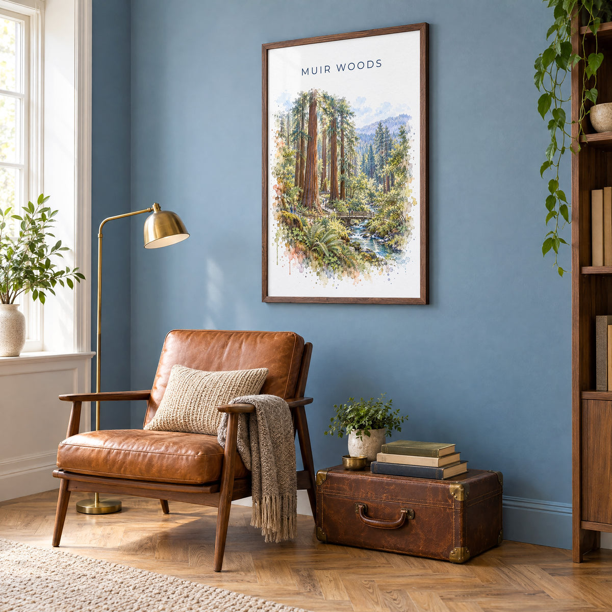 Muir Woods watercolor print in a walnut frame on a blue wall above a leather armchair in a reading nook