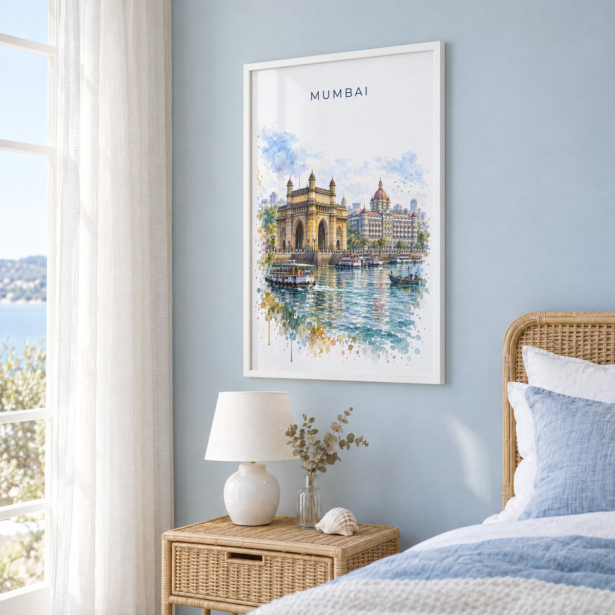 Mumbai watercolor print in a white frame on a pale blue wall beside a rattan bed in a coastal bedroom