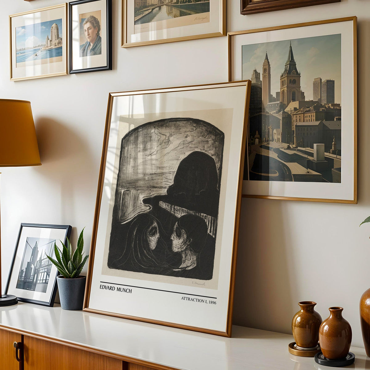Munch print shown in a gold frame leaning on a sideboard in a gallery wall