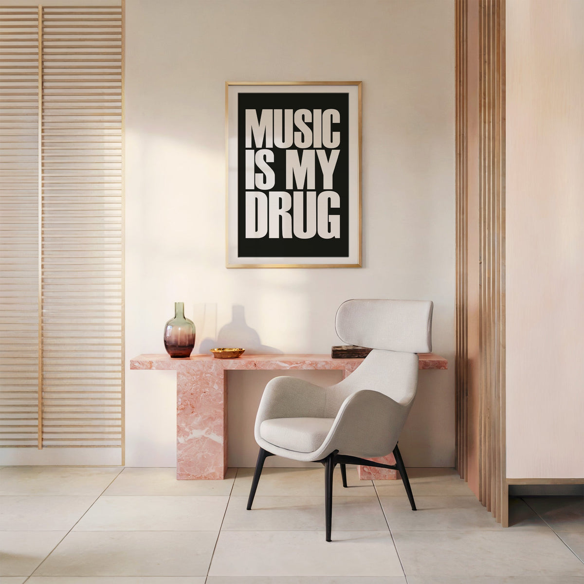 Music Is My Drug white lettering on black print shown in a gold frame above a pink marble console and armchair