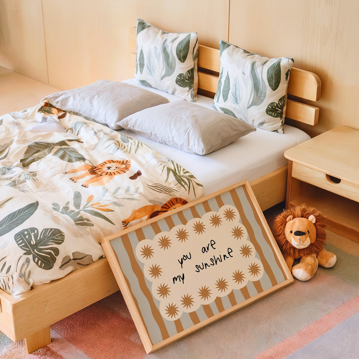 Landscape my sunshine sun border nursery print in an oak frame leaning on a kids bed by a lion plush