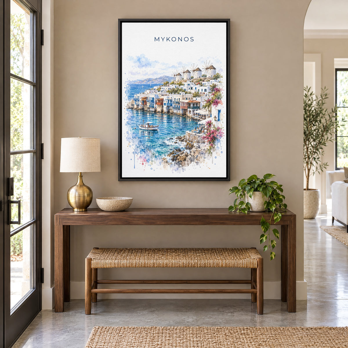 Mykonos watercolor print as a black floater canvas above a walnut console and woven bench in an entryway