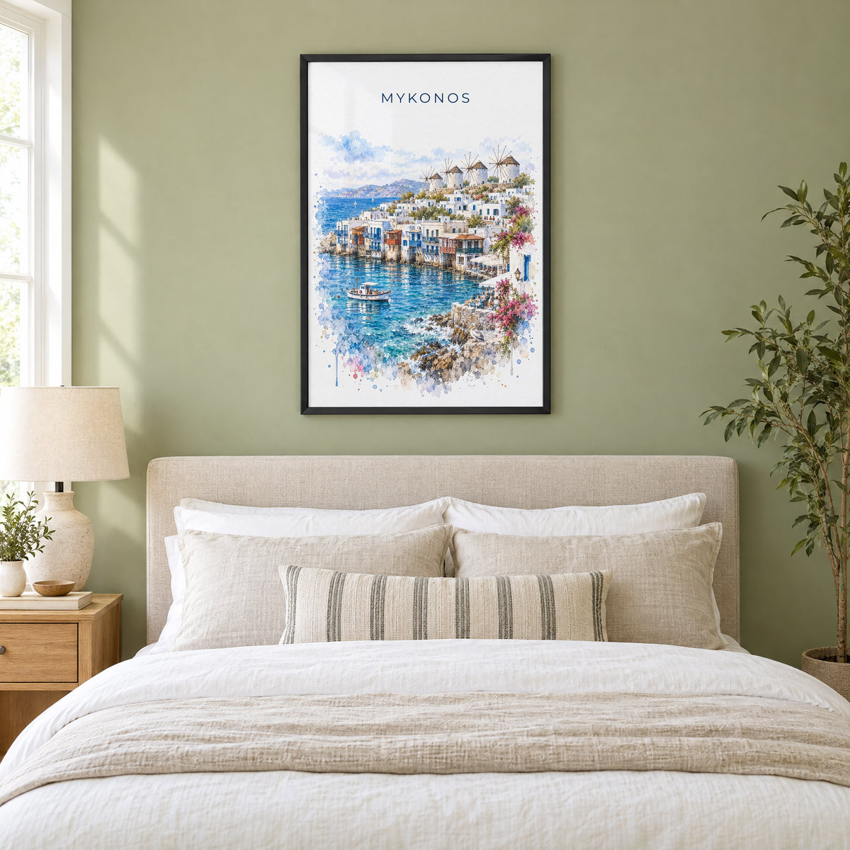Mykonos watercolor print in a black frame above an upholstered headboard in a sage green bedroom
