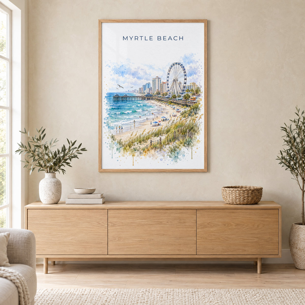 Myrtle Beach watercolor print in an oak frame above a light wood sideboard in a Scandinavian living room