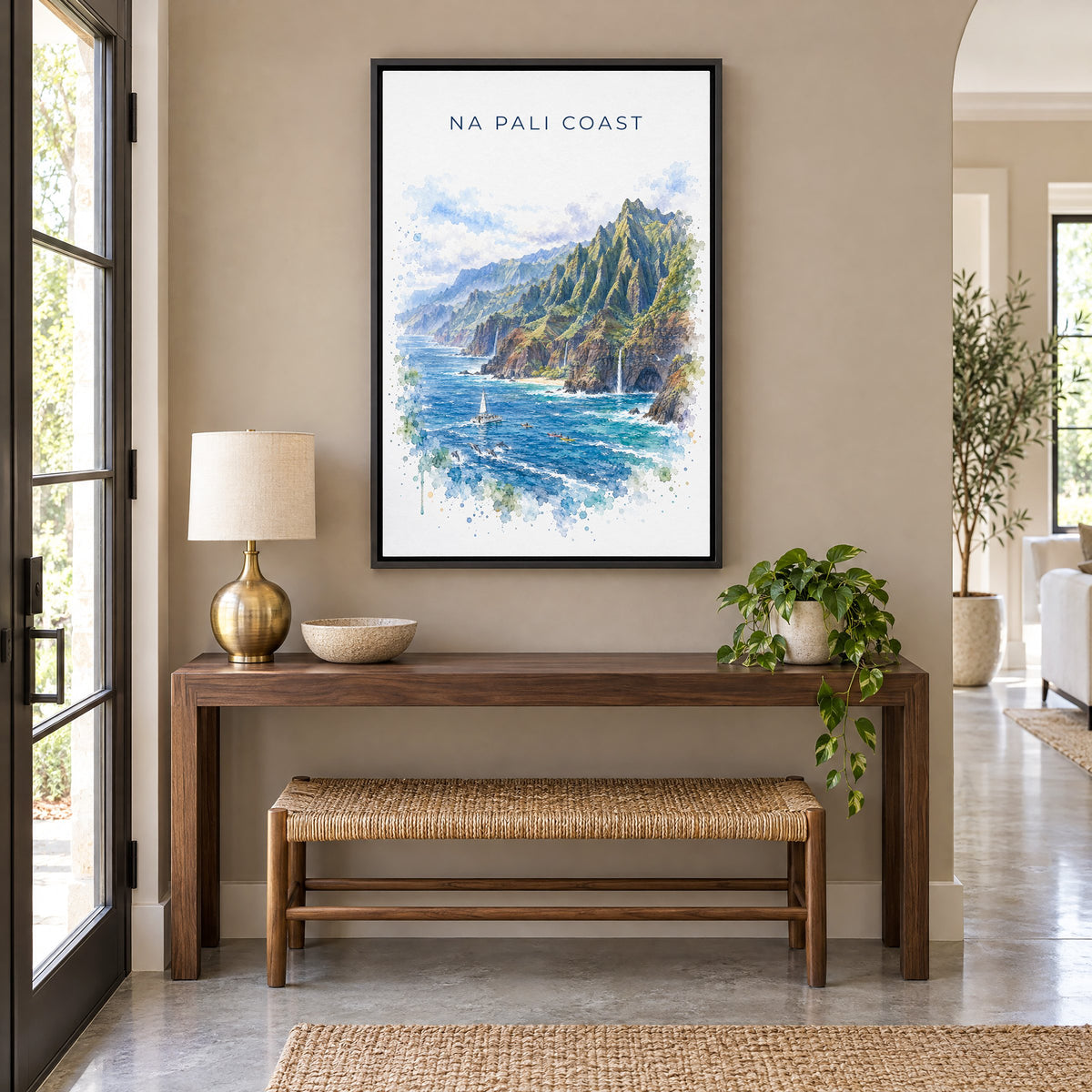 Na Pali Coast watercolor print as a black floater canvas above a walnut console and woven bench in an entryway