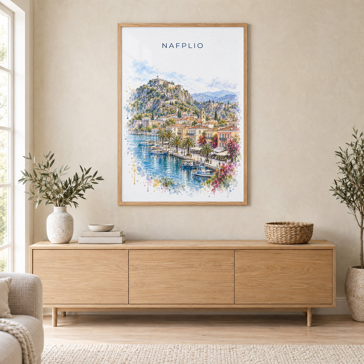 Nafplio watercolor print in an oak frame above a light wood sideboard in a Scandinavian living room