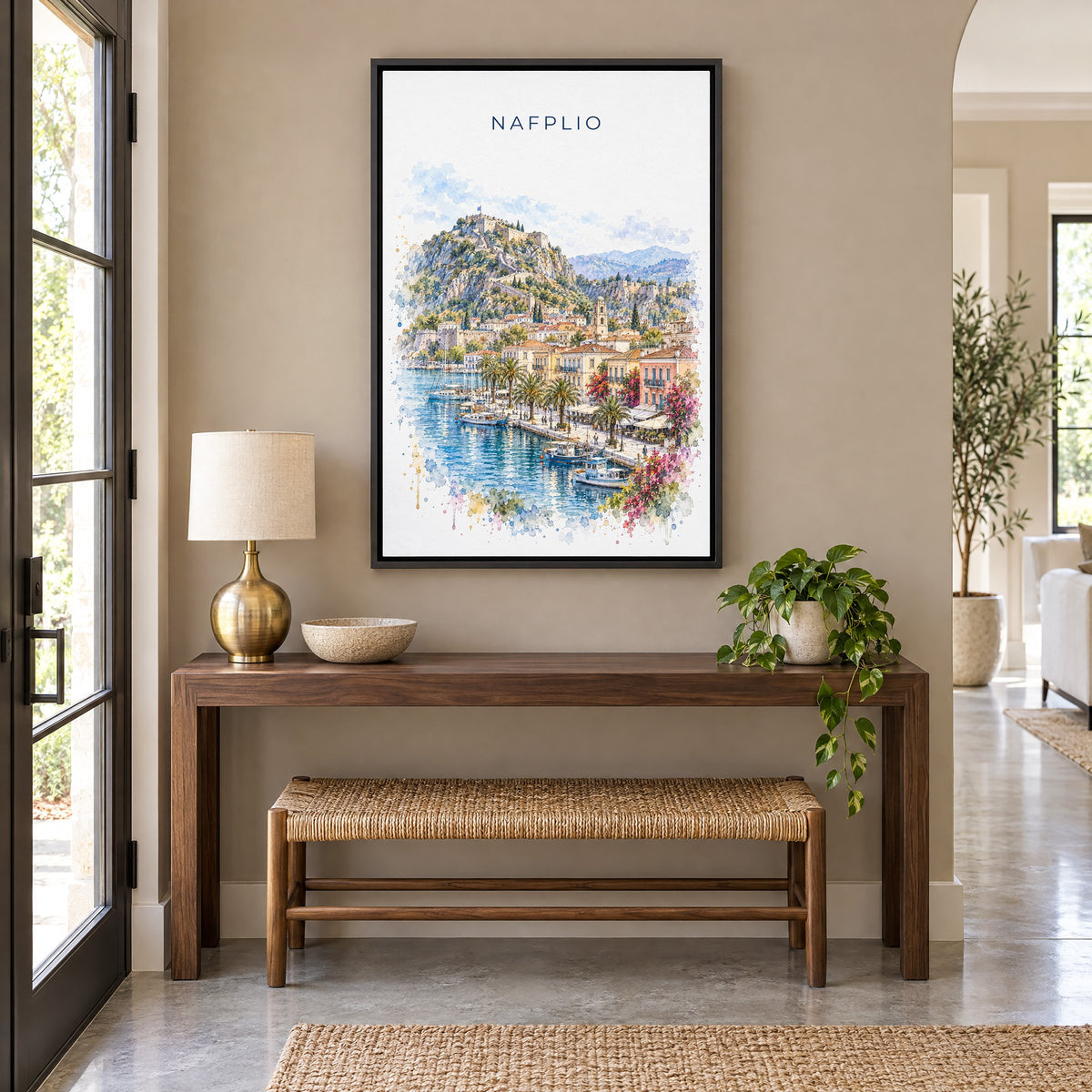 Nafplio watercolor print as a black floater canvas above a walnut console and woven bench in an entryway