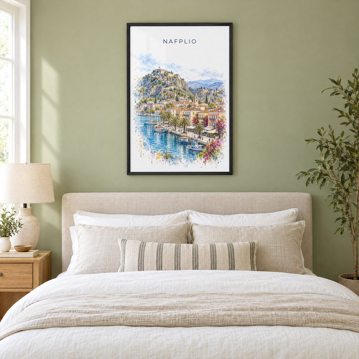 Nafplio watercolor print in a black frame above an upholstered headboard in a sage green bedroom
