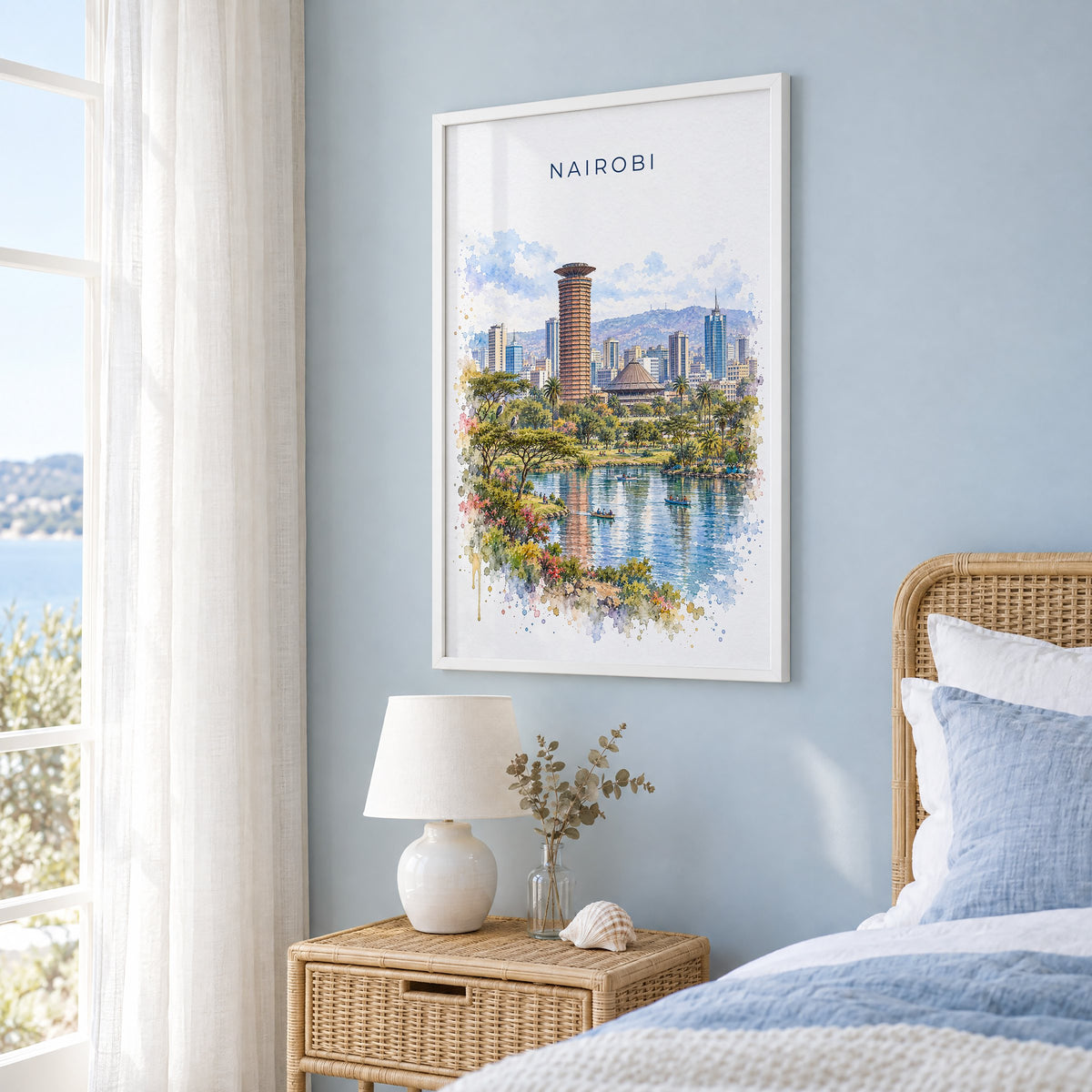 Nairobi watercolor print in a white frame on a pale blue wall beside a rattan bed in a coastal bedroom