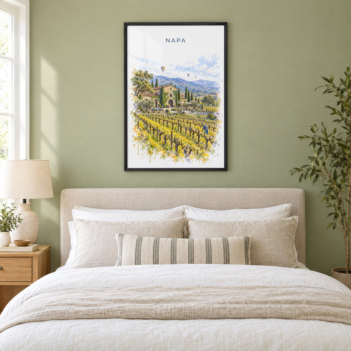 Napa watercolor print in a black frame above an upholstered headboard in a sage green bedroom