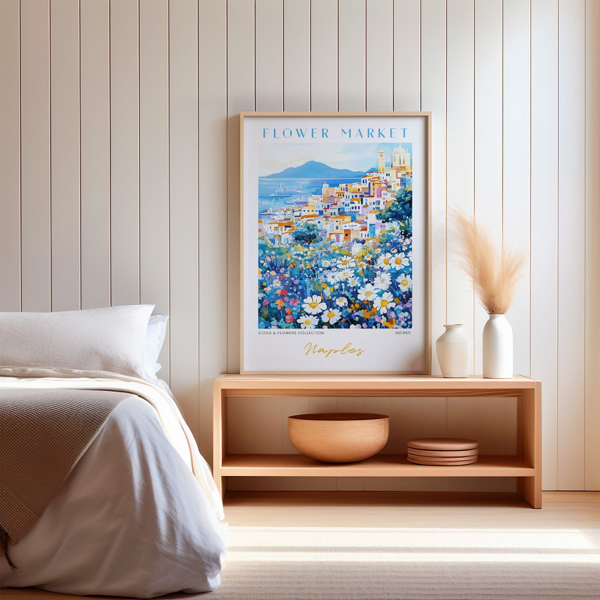 Naples flower market print in an oak frame on a wood bench against a white shiplap bedroom wall with pampas grass