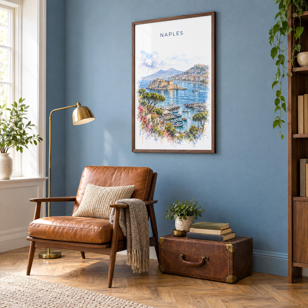 Naples, Italy watercolor print in a walnut frame on a blue wall above a leather armchair in a reading nook