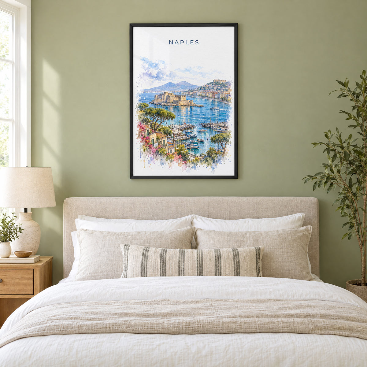 Naples, Italy watercolor print in a black frame above an upholstered headboard in a sage green bedroom