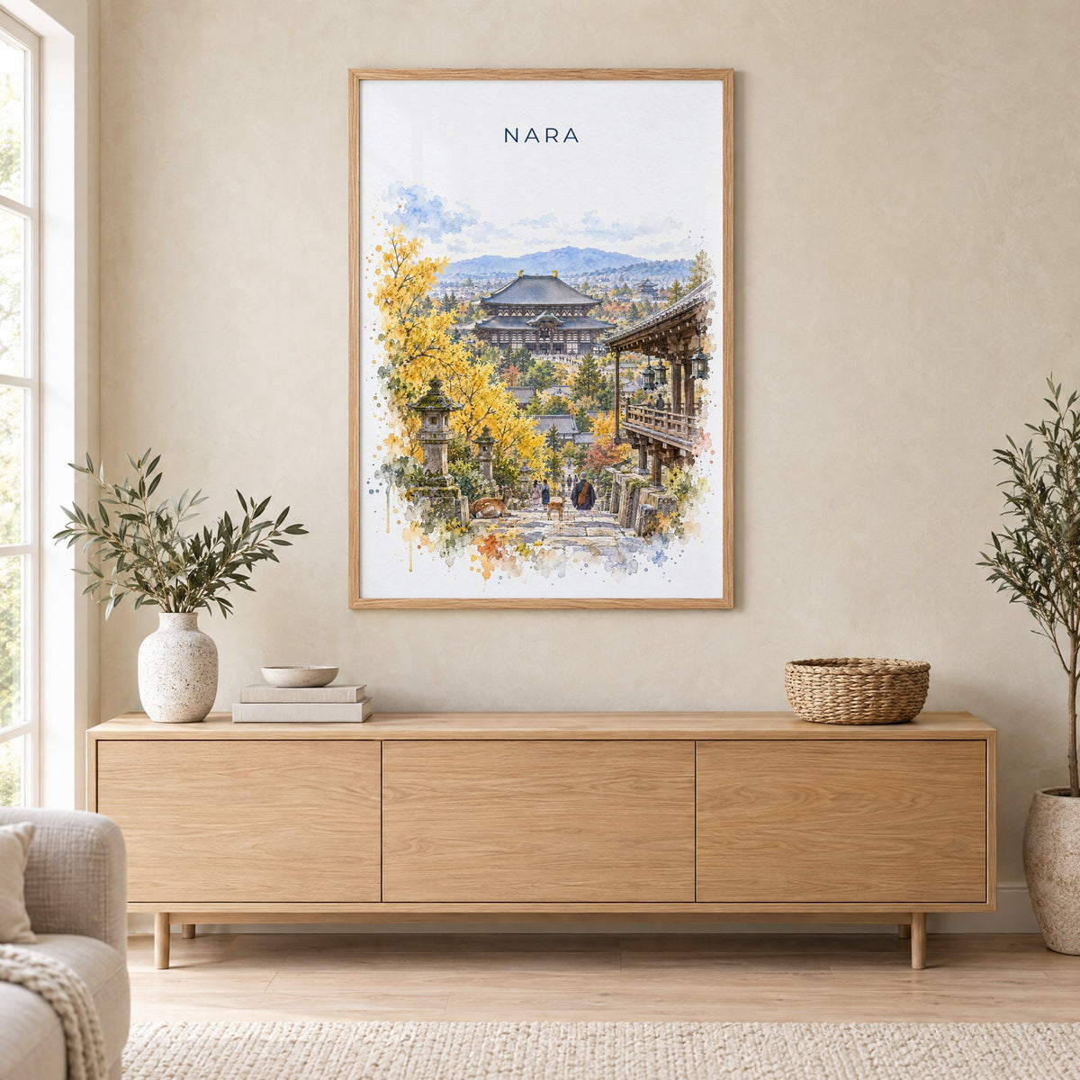 Nara watercolor print in an oak frame above a light wood sideboard in a Scandinavian living room