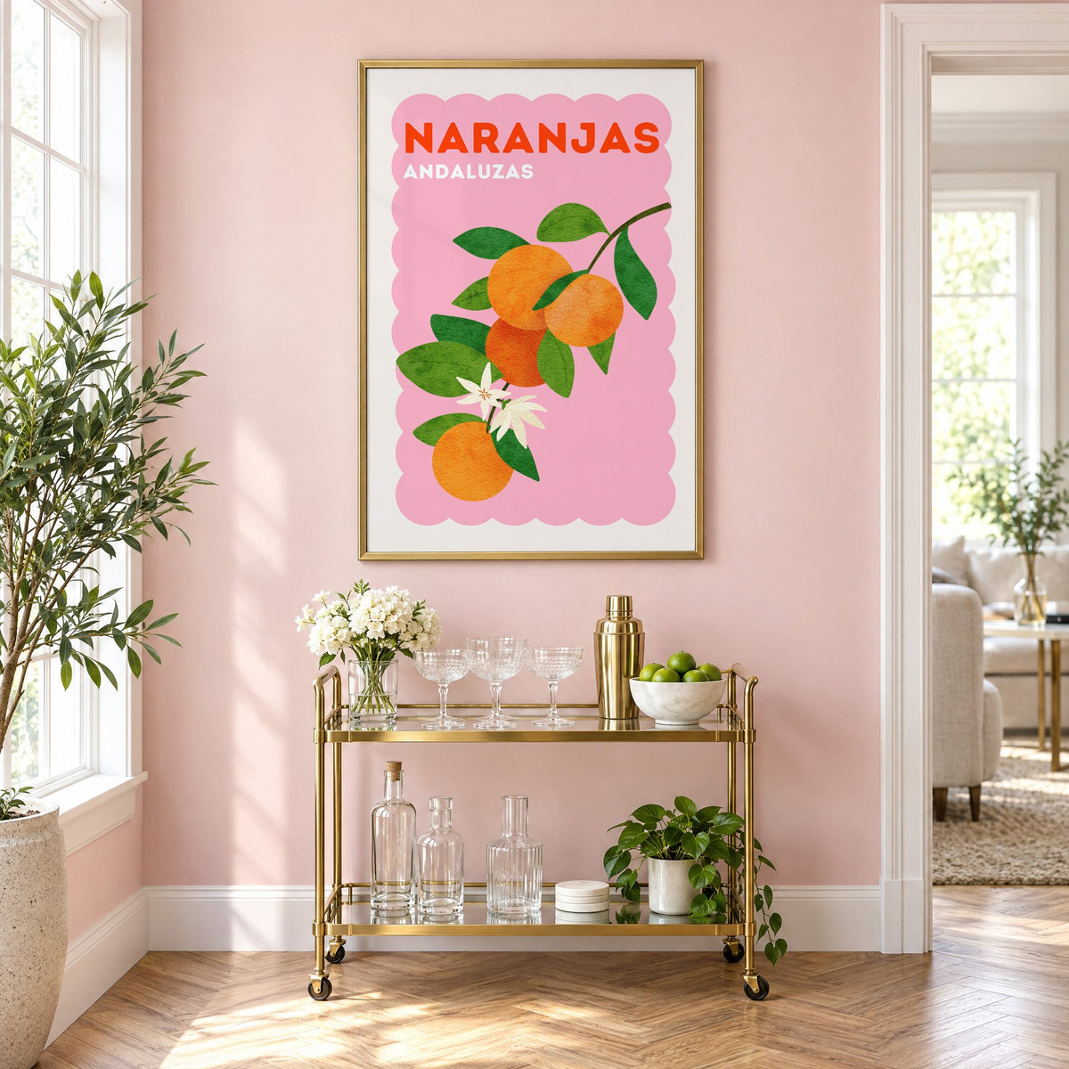 Naranjas Andaluzas orange branch print in a brass frame above a gold bar cart on a blush pink wall