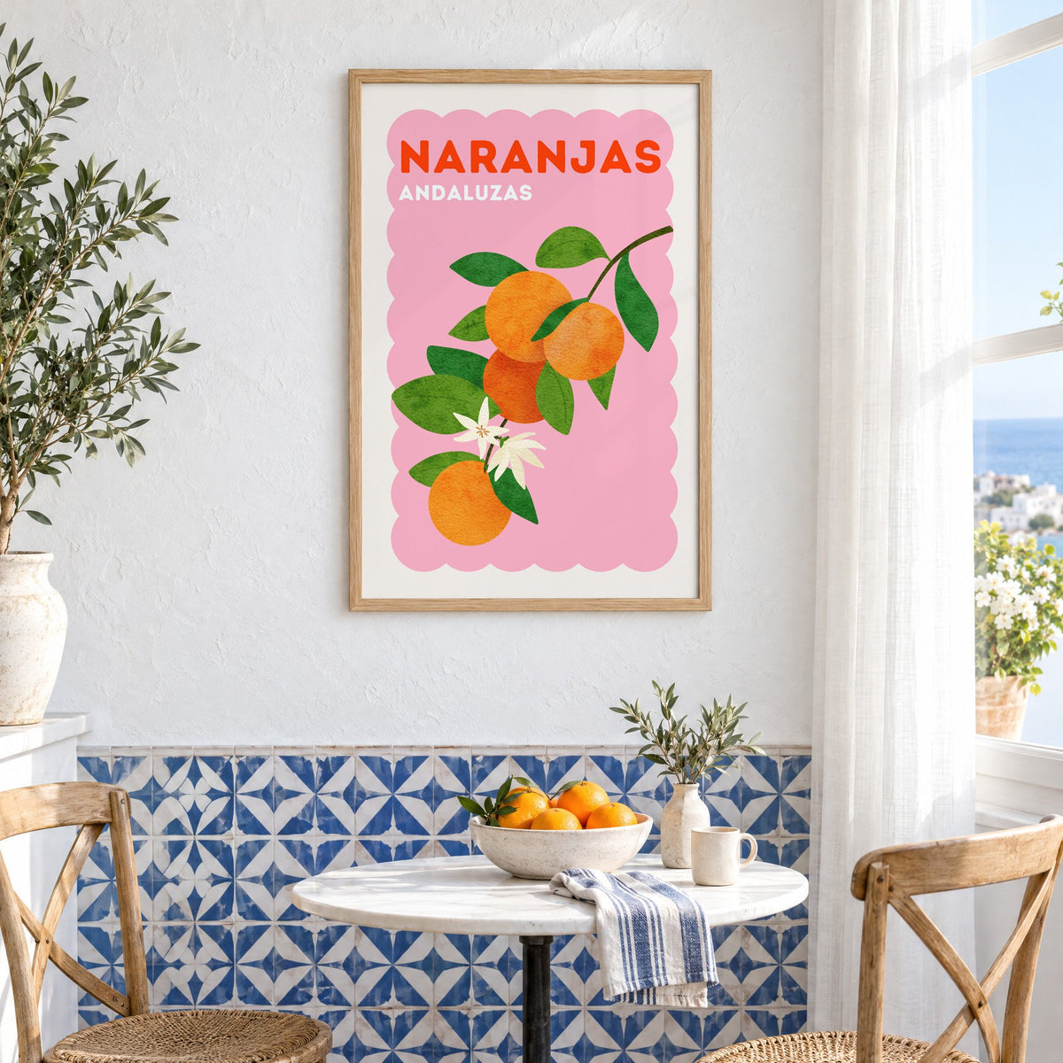 Naranjas Andaluzas orange branch print in an oak frame above a bistro table and blue patterned tiles