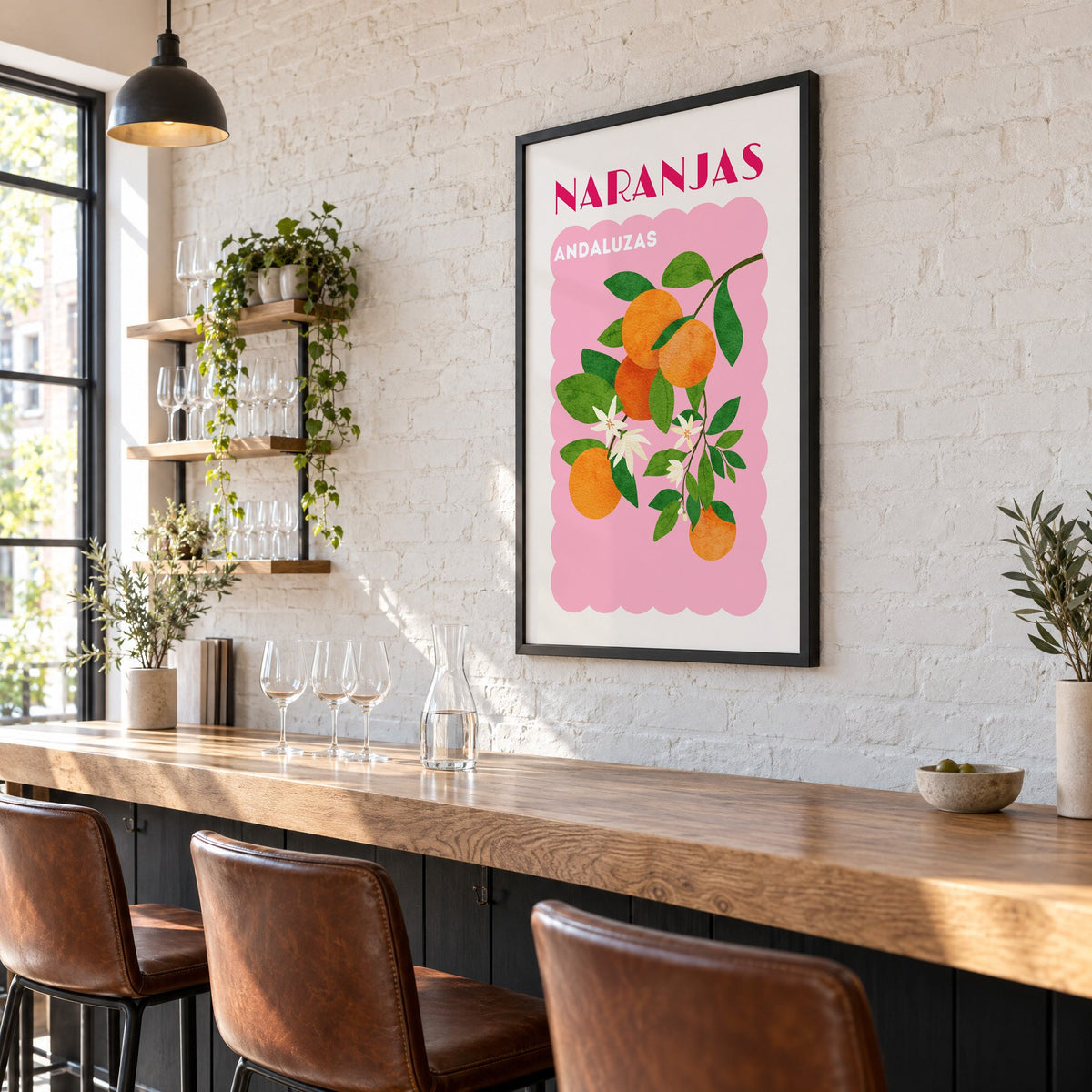 NARANJAS ANDALUZAS orange branch print in a black frame on a white brick wall above a wine bar counter