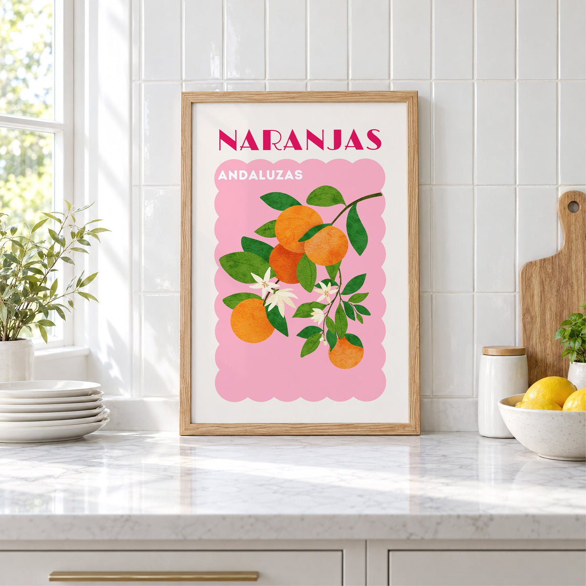 NARANJAS ANDALUZAS orange branch print in an oak frame leaning on a marble counter by white tiles and lemons