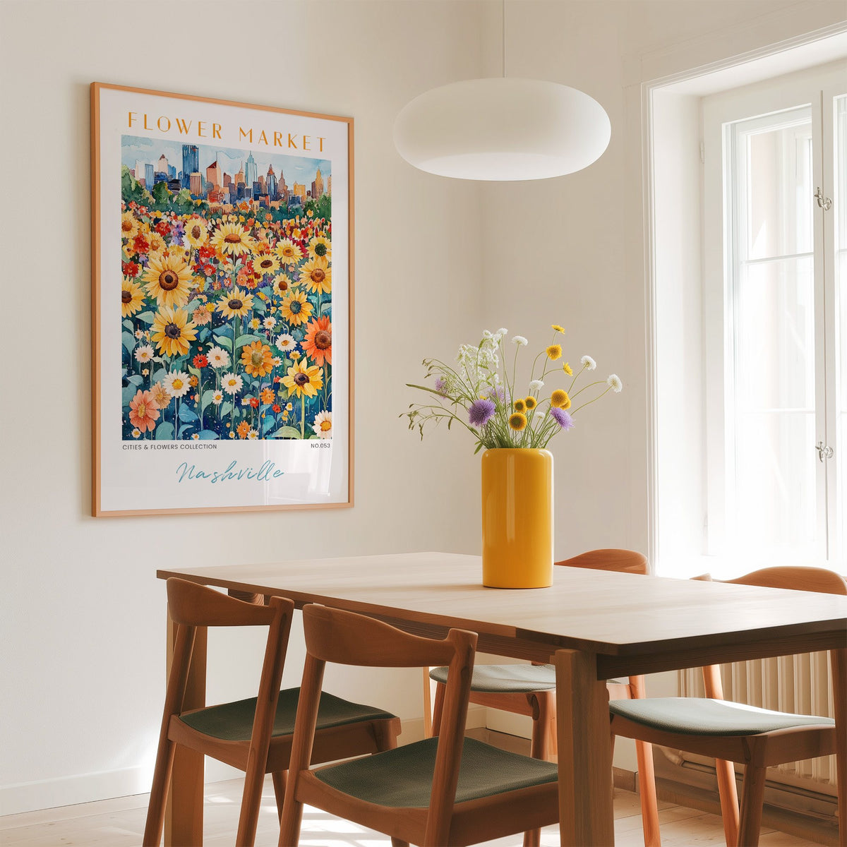 Nashville flower market print in an oak frame above a dining table with a yellow vase and white pendant light