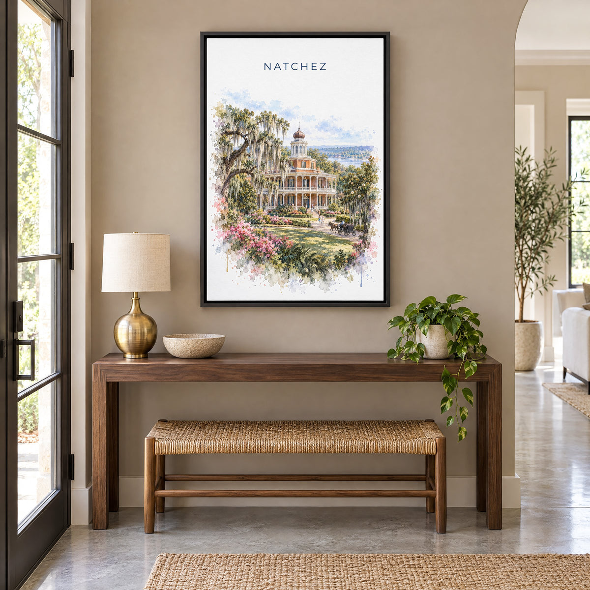 Natchez watercolor print as a black floater canvas above a walnut console and woven bench in an entryway