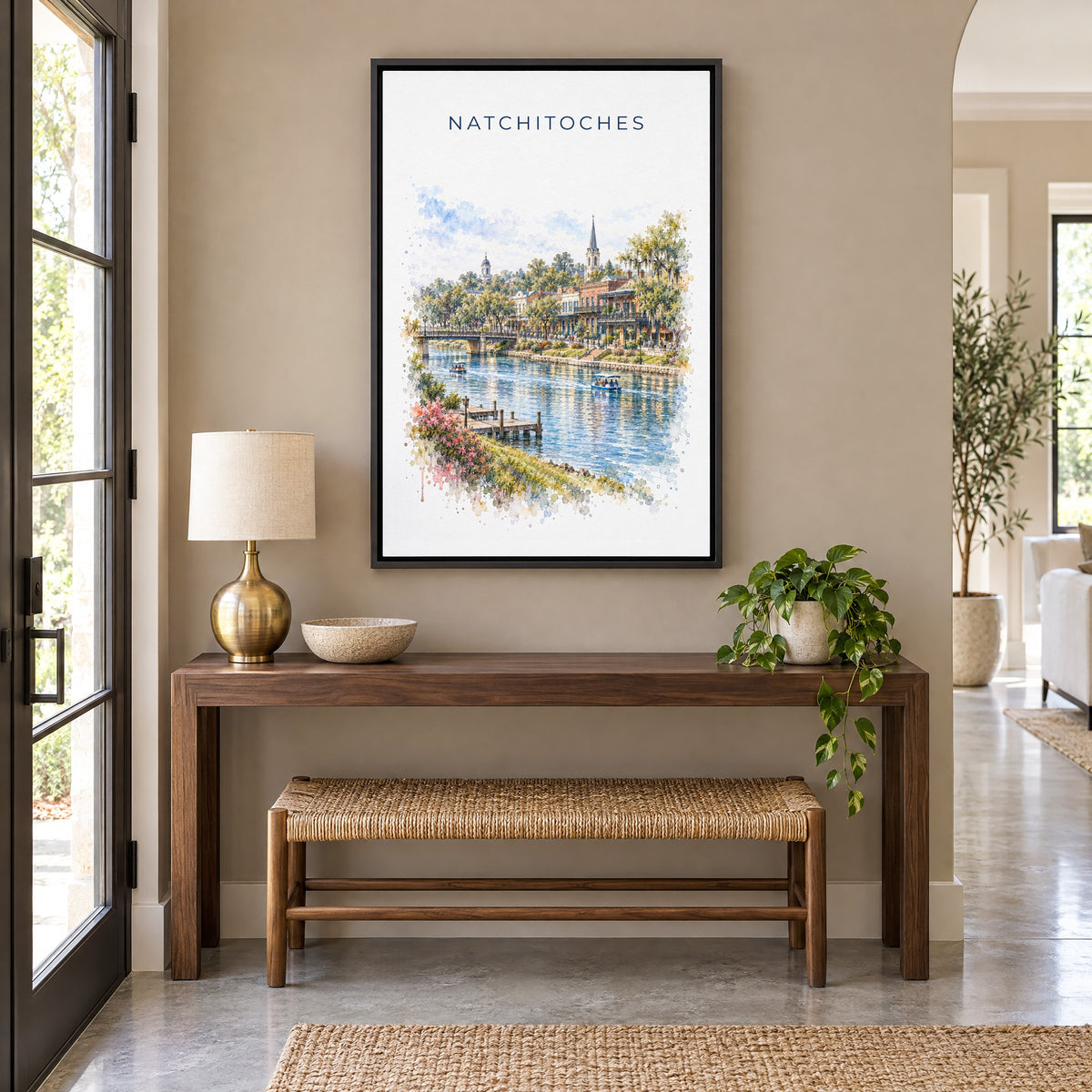 Natchitoches, Louisiana watercolor print as a black floater canvas above a walnut console and woven bench in an entryway