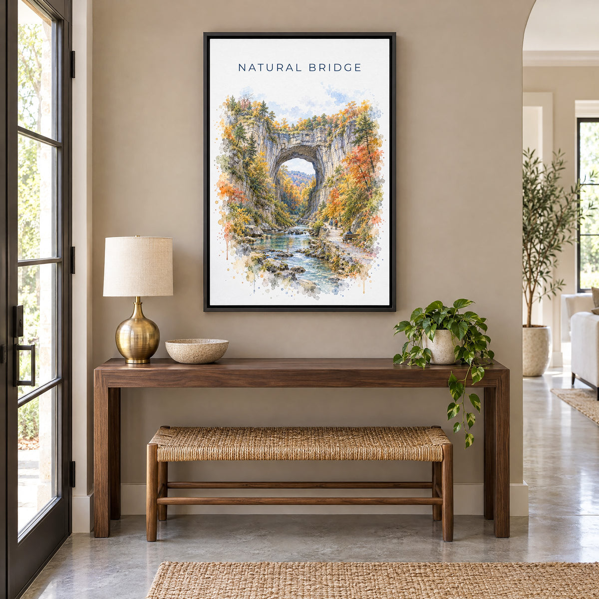 Natural Bridge, Virginia watercolor print as a black floater canvas above a walnut console and woven bench in an entryway
