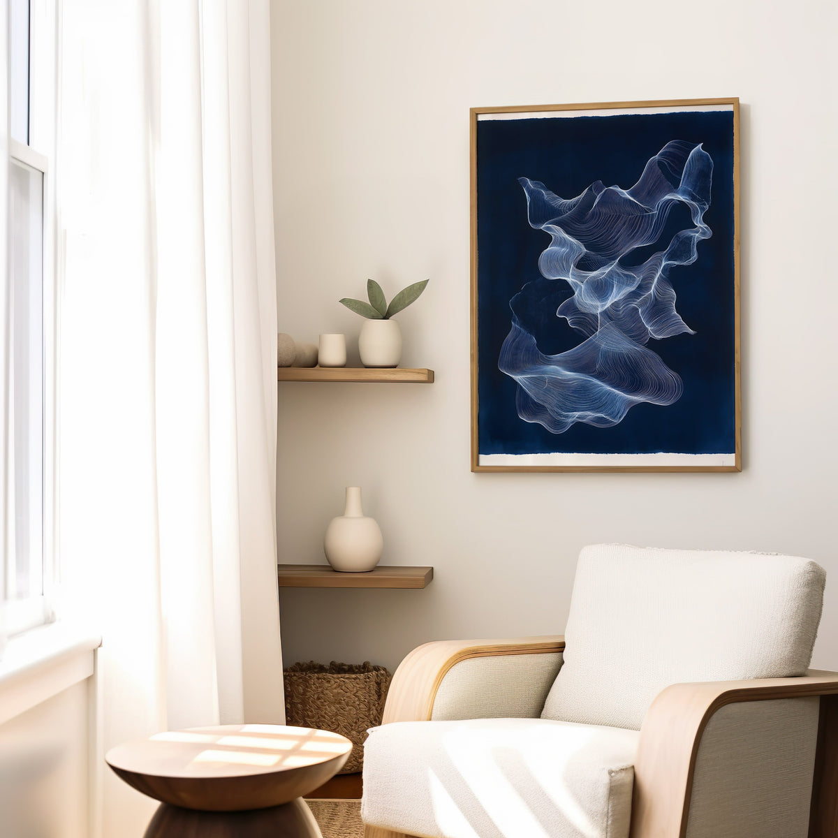 Navy and white line ribbon abstract print in a slim oak frame above a cream boucle armchair by floating shelves