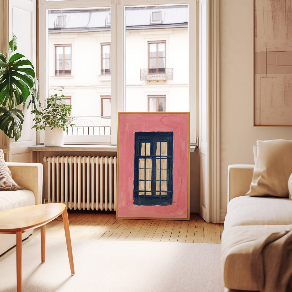 Pink wall window print in an oak frame leaning below tall French windows