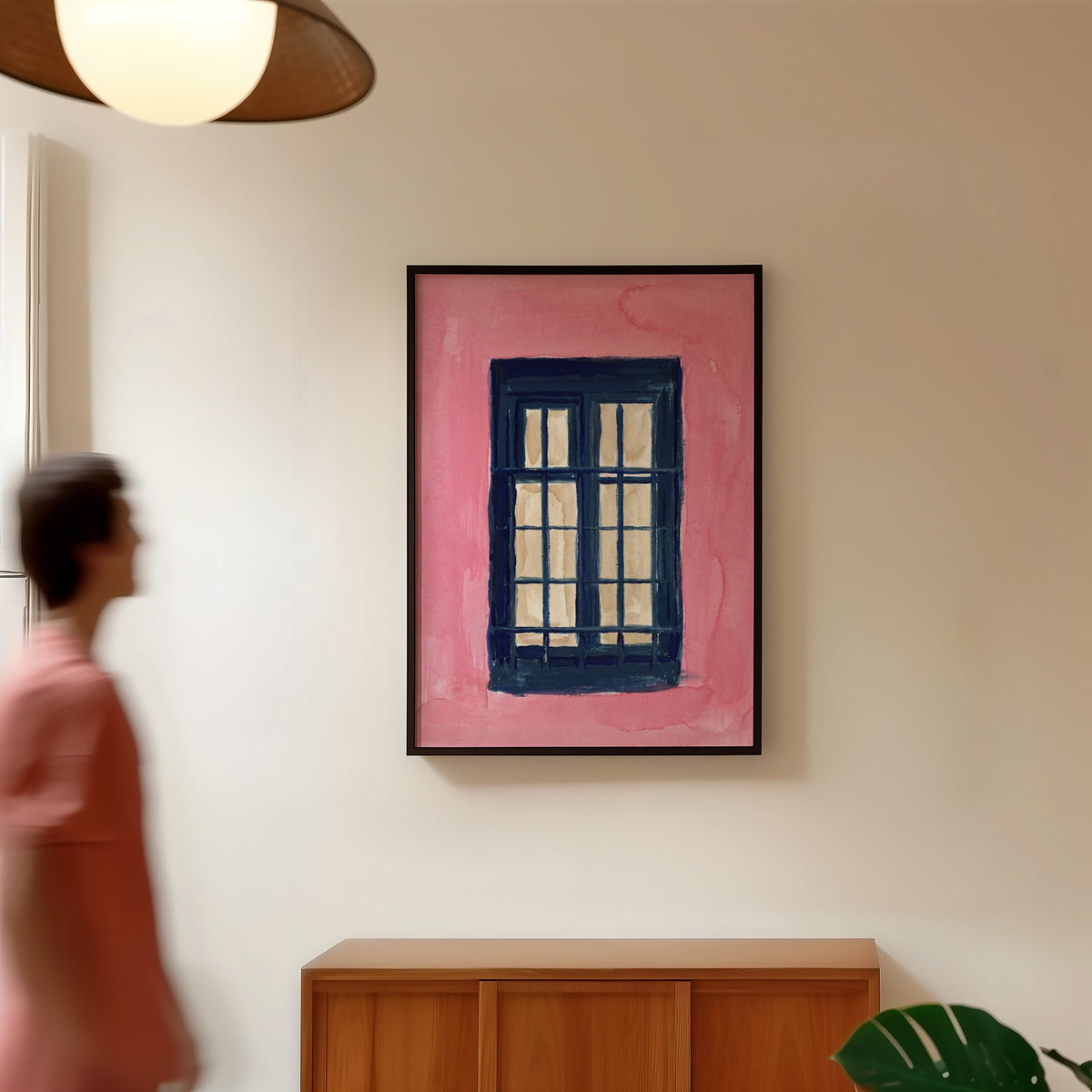 Mediterranean window print in a black frame in a hallway under a rattan pendant
