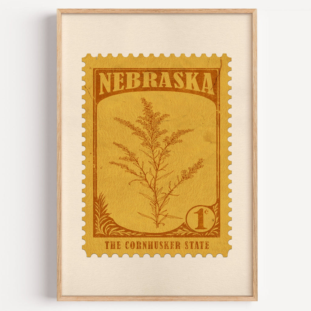 Nebraska state flower stamp print in ochre brown on mustard, light oak frame on a plain white wall