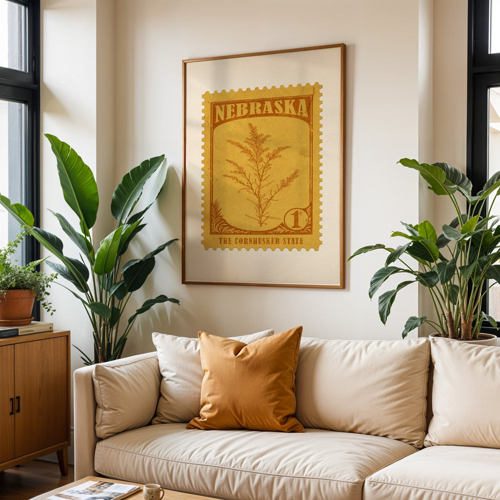 Nebraska state flower print framed above a cream sofa with an ochre cushion and large plants either side