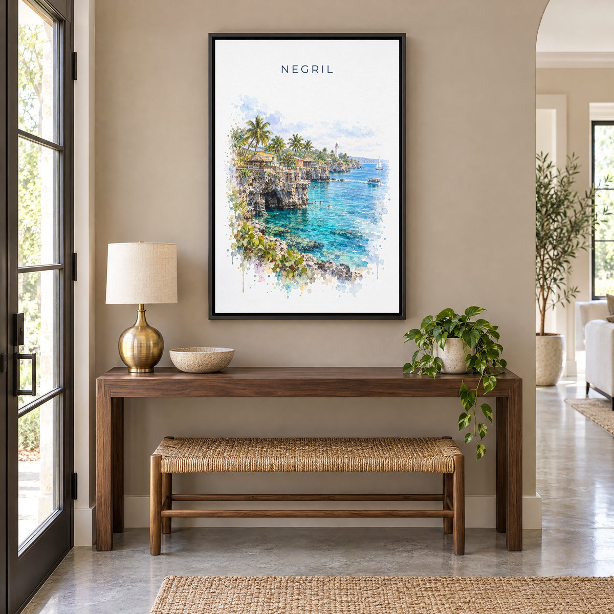 Negril watercolor print as a black floater canvas above a walnut console and woven bench in an entryway