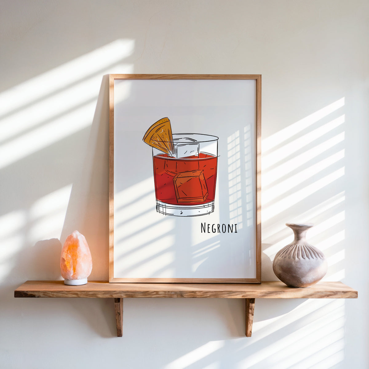 Negroni line print in an oak frame on a live-edge shelf beside a salt lamp