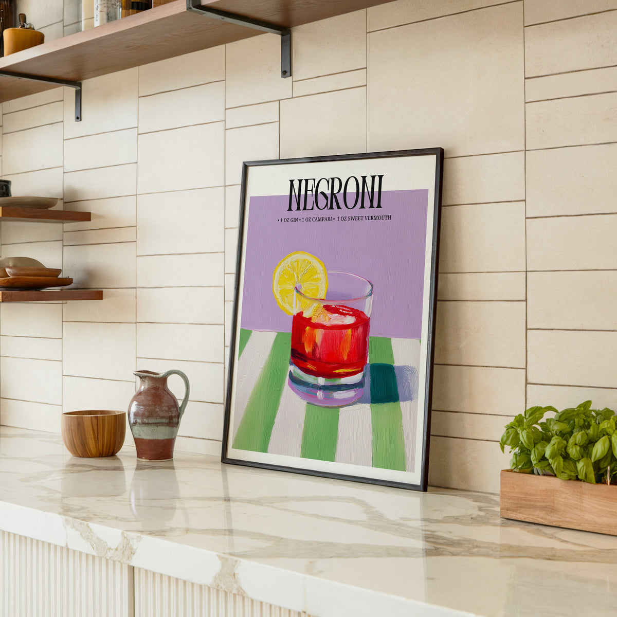 Negroni painterly print in a black frame leaning on a marble counter in a tiled kitchen