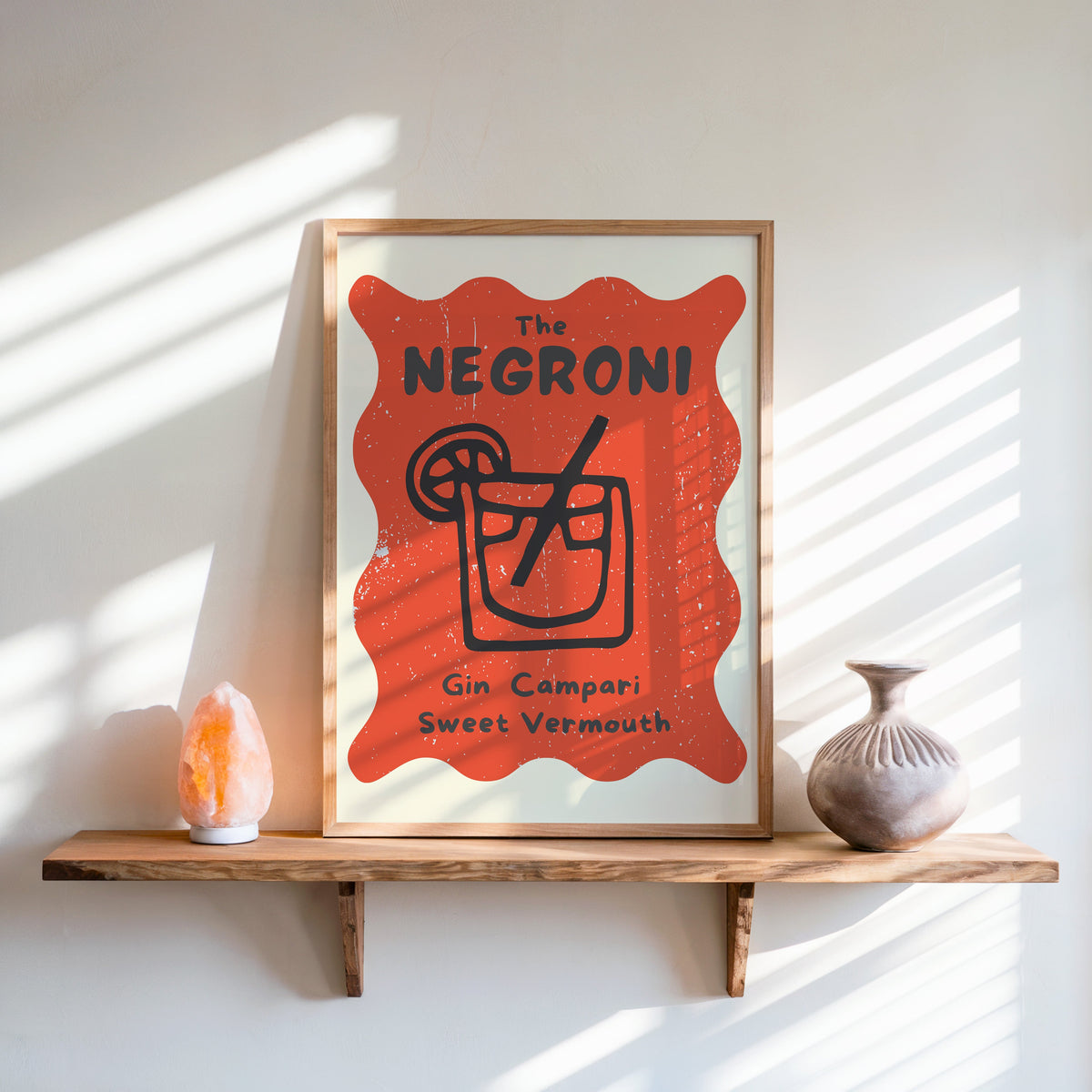 Negroni print in an oak frame on a live-edge shelf beside a salt lamp