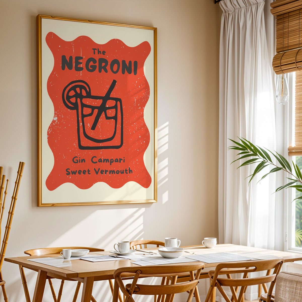 Negroni print shown in a gold frame above a breakfast table by a curtained window