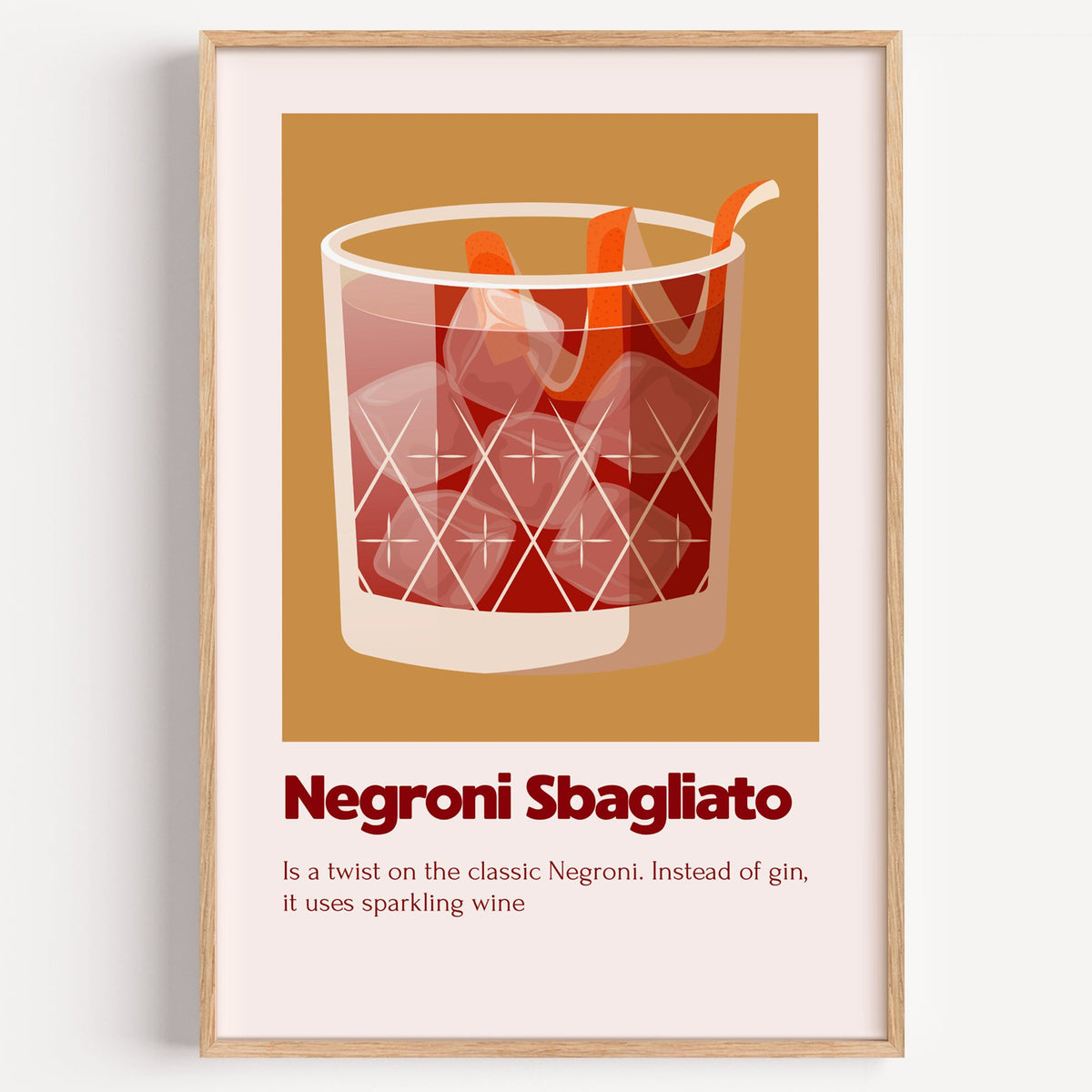Negroni Sbagliato rocks glass ochre card print in a light oak frame on a plain white wall