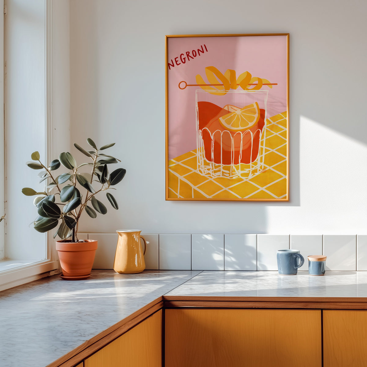 Negroni print in a gold frame above a marble counter with a yellow ceramic jug