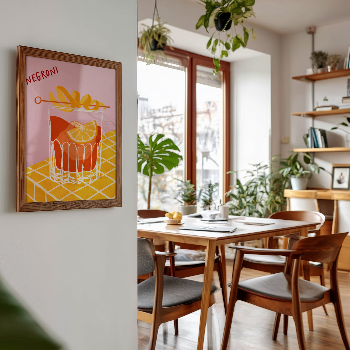 Negroni print in a walnut frame beside a mid-century dining table