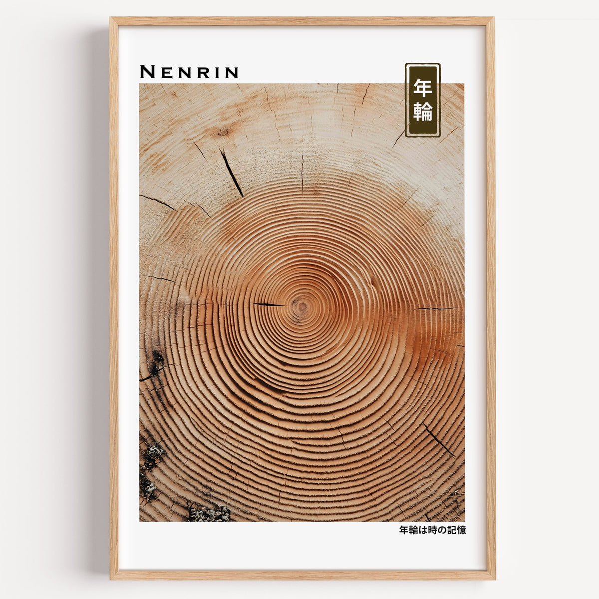 Orange-brown wood slice tree rings print in a light oak frame on a plain white wall