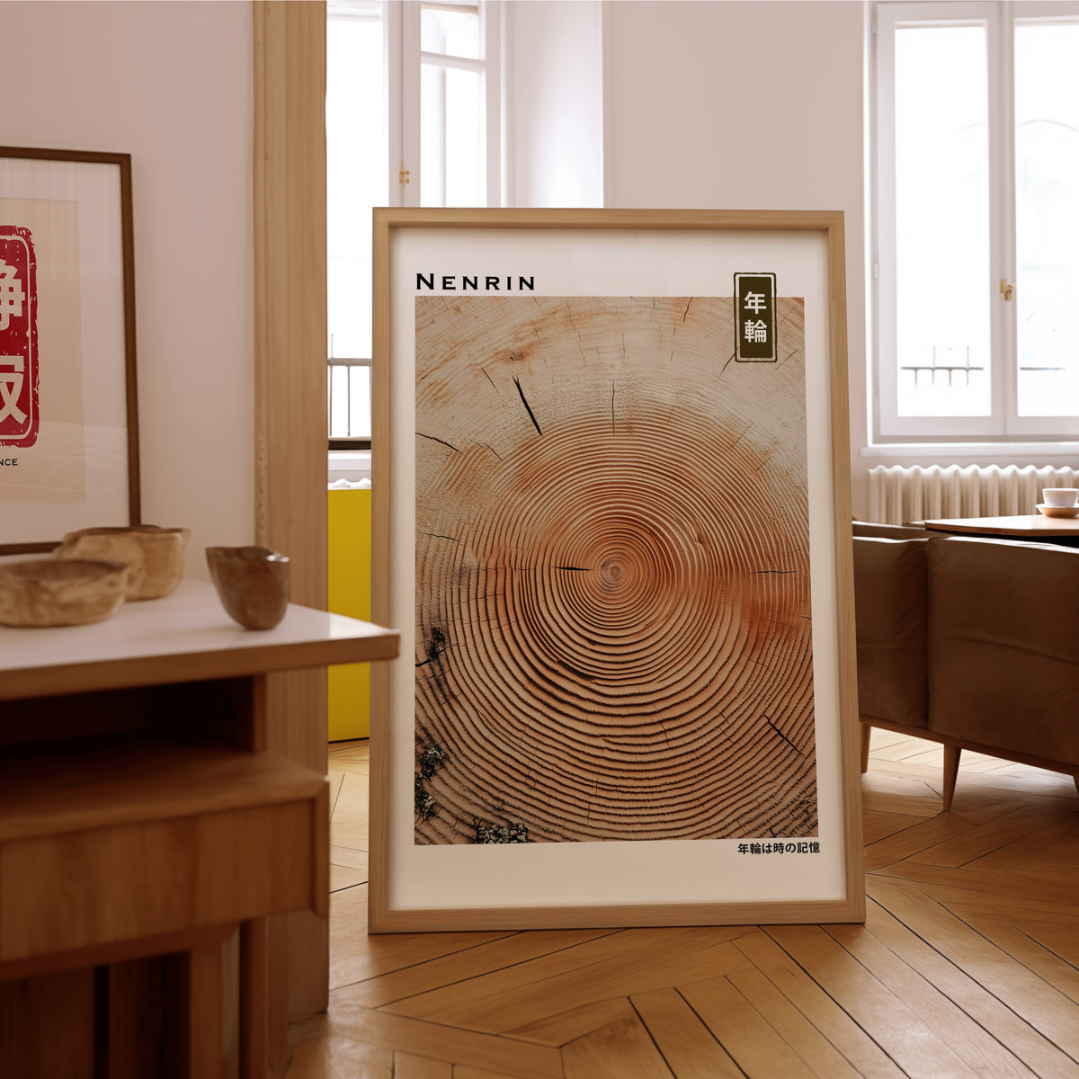 Orange-brown wood slice tree rings print in an oak frame on the parquet floor of a sunlit living room