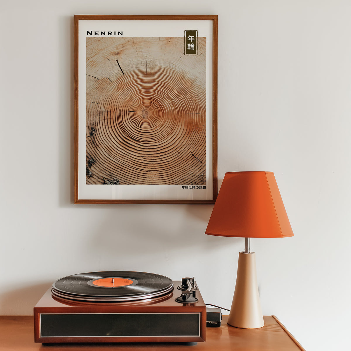 Orange-brown wood slice tree rings print in a walnut frame above a sideboard with a record player