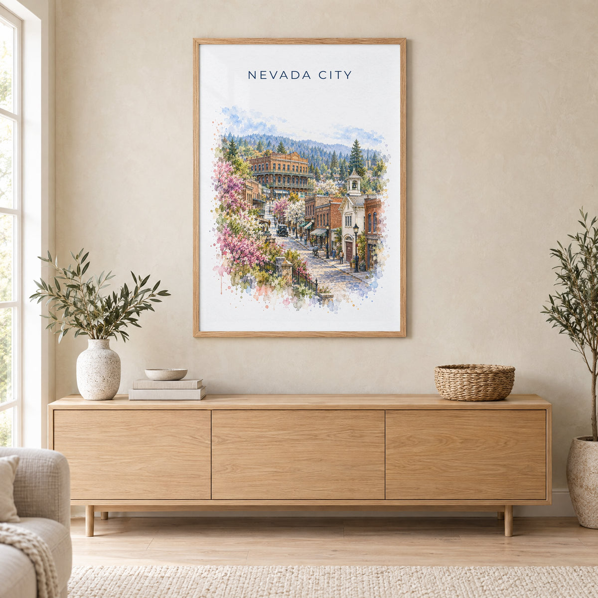 Nevada City, California watercolor print in an oak frame above a light wood sideboard in a Scandinavian living room