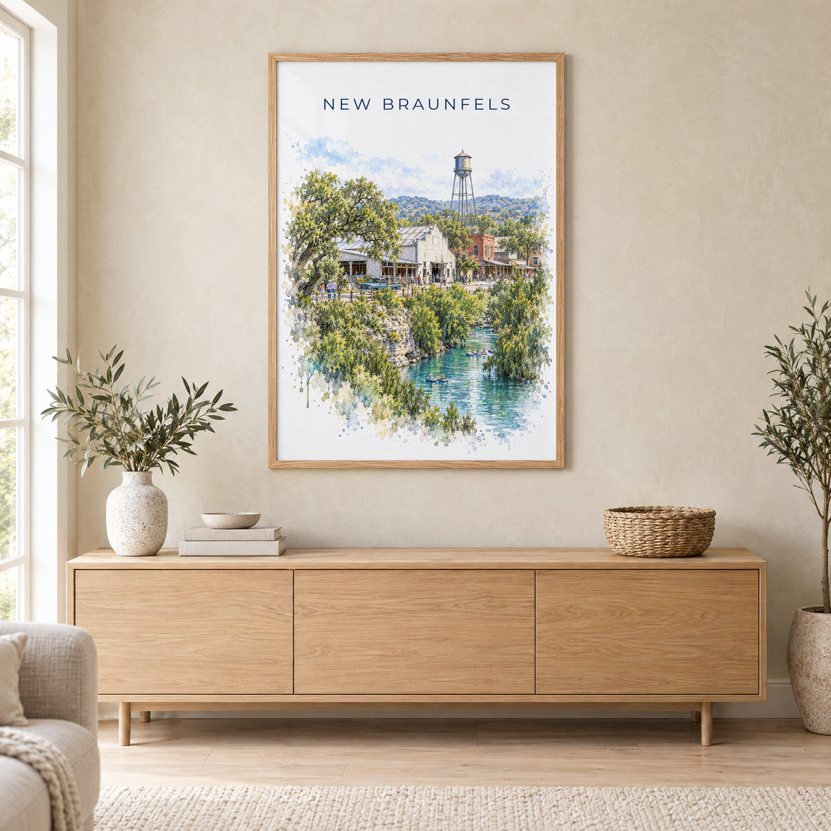 New Braunfels watercolor print in an oak frame above a light wood sideboard in a Scandinavian living room