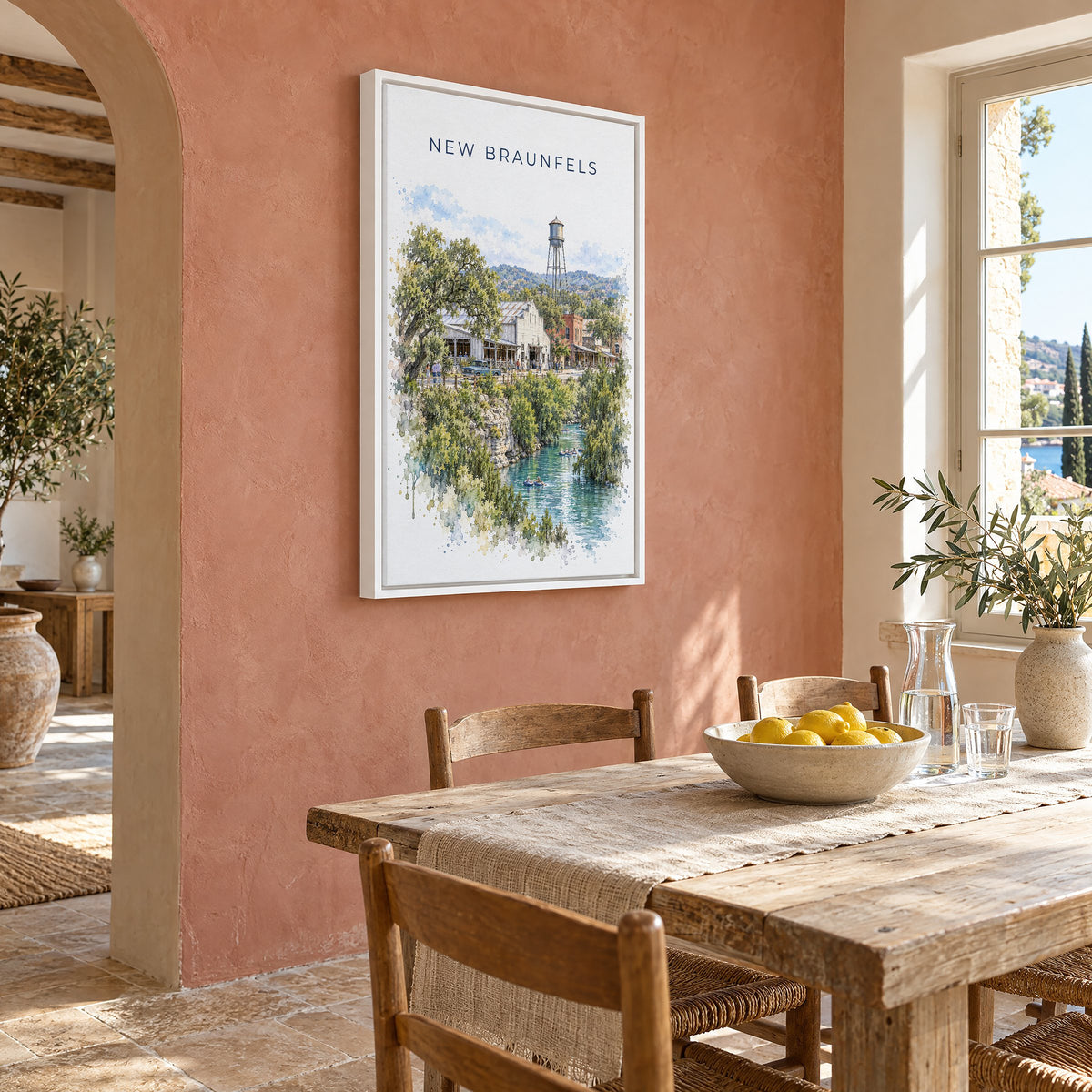 New Braunfels watercolor print as a white floater canvas on a terracotta wall above a rustic dining table