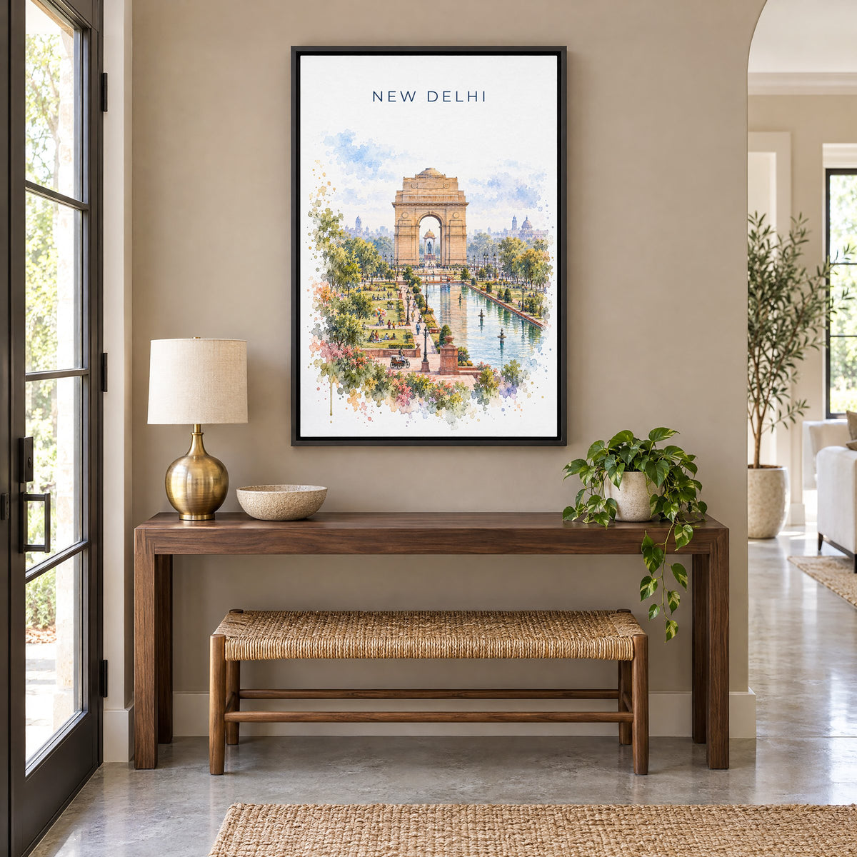 New Delhi watercolor print as a black floater canvas above a walnut console and woven bench in an entryway