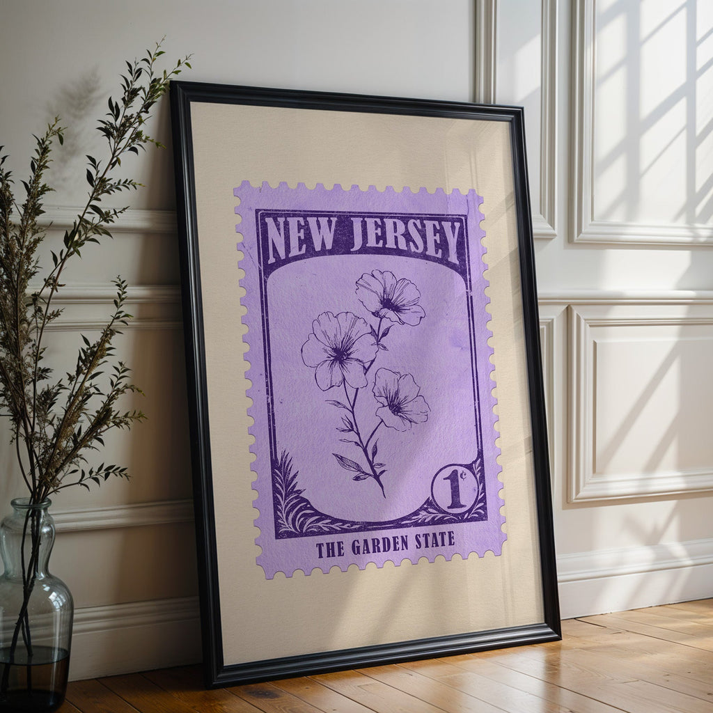 New Jersey state flower print in a black frame leaning against a white panelled wall beside olive branches
