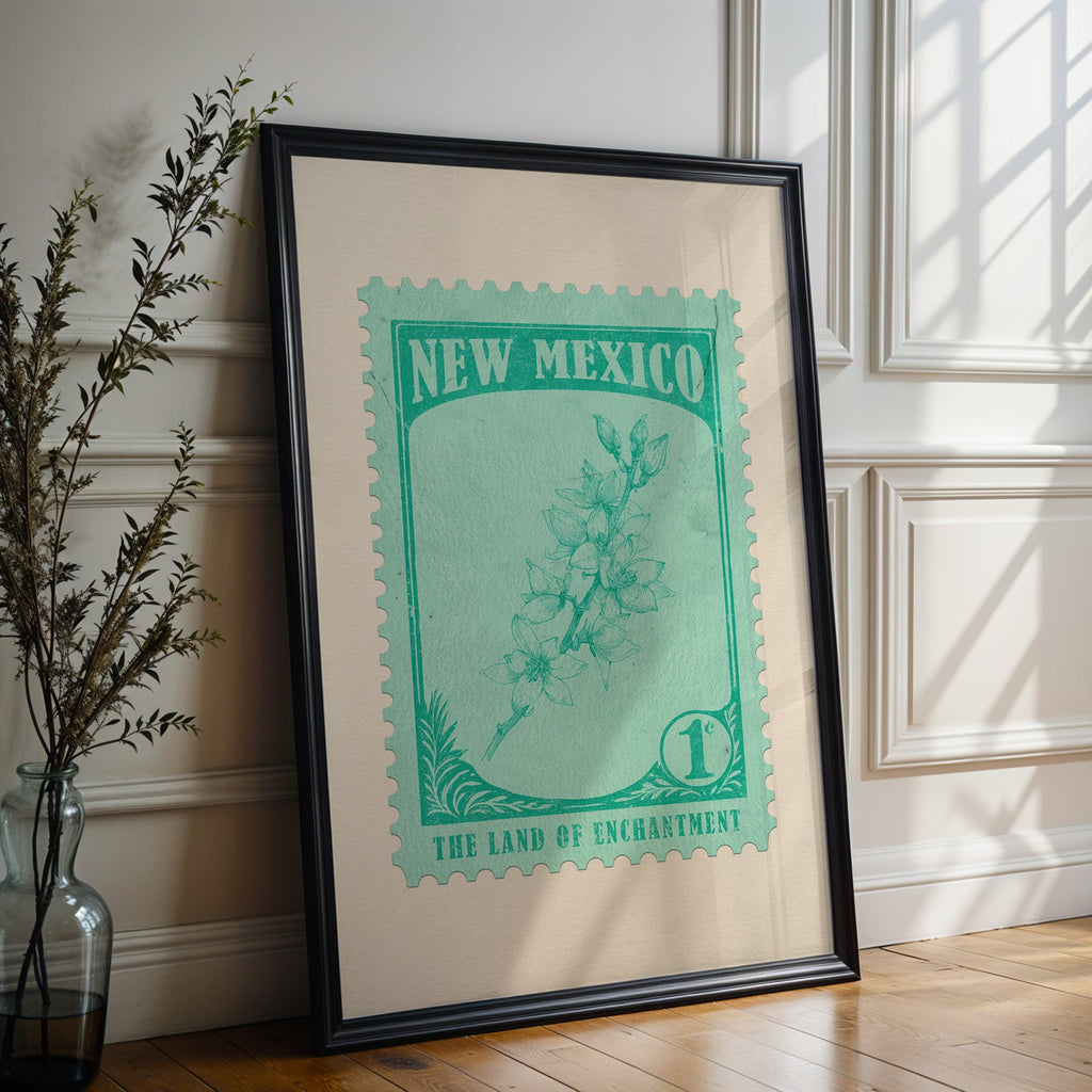 New Mexico state flower print in a black frame leaning against a white panelled wall beside olive branches